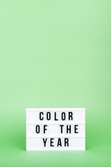 Retro lightbox with Color of the year wording on the trendy solid green backdrop in vertical format, place for text