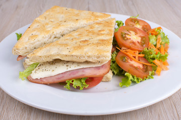 Craft sandwich with oregano, ham, cheese and salad