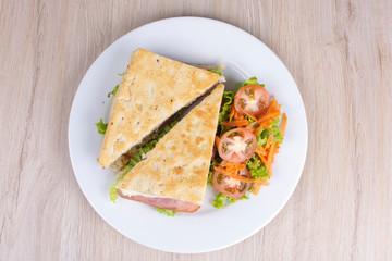 Craft sandwich with oregano, ham, cheese and salad