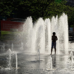 Silhouette of a child having fun in a fountain