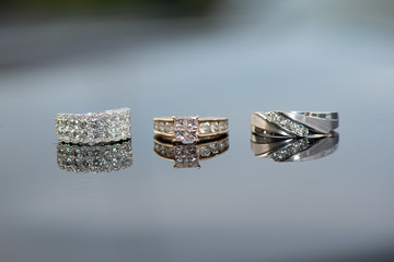 white gold wedding rings with diamonds  side by side and glass reflective serface