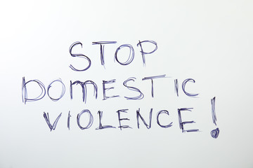 Phrase STOP DOMESTIC VIOLENCE on white background, top view