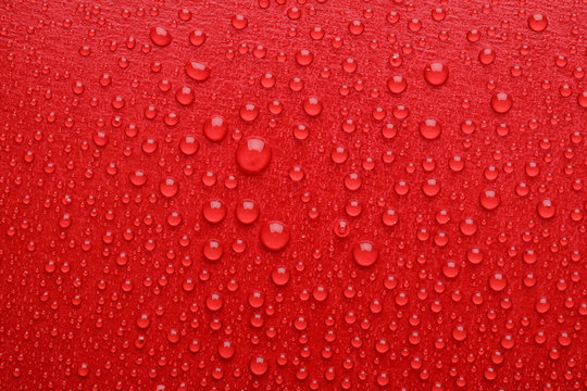 Water drops on red background, top view
