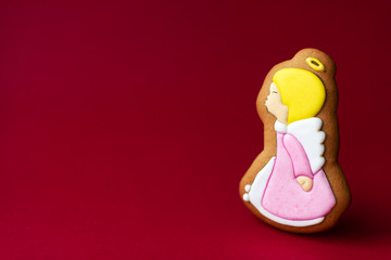 gingerbread cookie of little cute angels on red background. Traditional Christmas food. Christmas and New Year holiday concept.