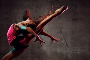 Fototapeten Street Dance Girl Tänzerin springt auf und tanzt im Neonlicht und macht Gymnastikübungen © Dmitry Lobanov