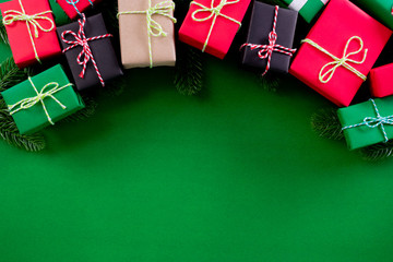 Christmas background concept. Top view of Christmas gifts and fir branches on green background. Copy space.