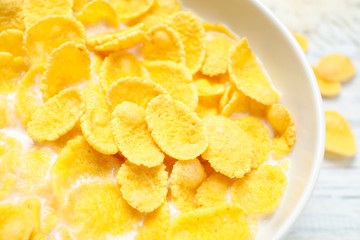 Tasty corn flakes with milk on table, closeup