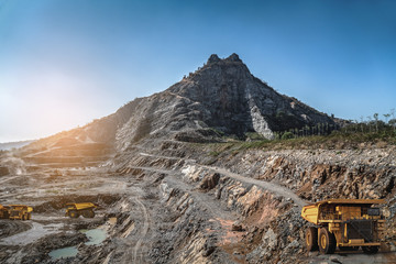 Yellow dump truck loading minerals copper, silver, gold, and other  at mining quarry. © JT Jeeraphun