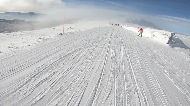 snowboarder slopes down hill. Action camera is on snowboarder's helmet