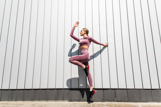 Muscular build young woman jumping and running outdoor