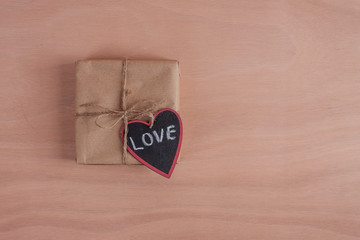 one paper wrapped gift with wooden heart plywood