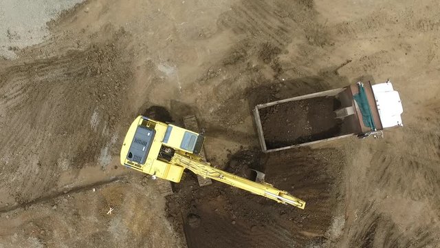 Excavator loading a truck with dirt