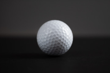 white golf ball on black background copy space