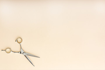 Hairdresser tools. Hairdresser scissors on beige color background with copy space for text....