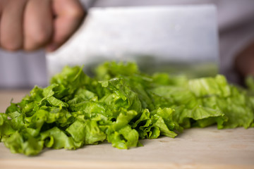 Fresh lettuce leaf and kitchen knife on wooden board. Food making