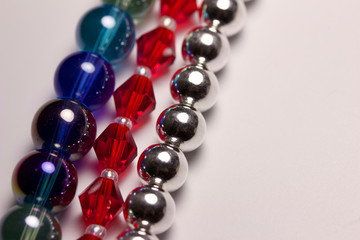 Macro abstract texture border of colorful strands of beads on white background with copy space