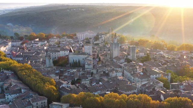 Large aerial view over Uzes city during sunrise France Gard beautiful village with trees around 
