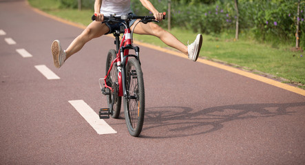 Woman cyclist riding mountain bike outdoors,have fun with legs outstretched