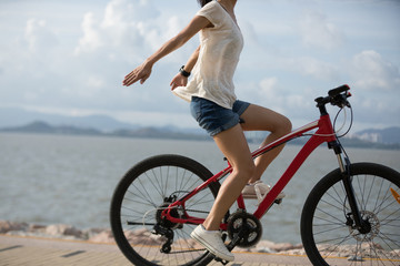 Fototapeta na wymiar Woman cyclist riding Mountain Bike on sunrise seaside
