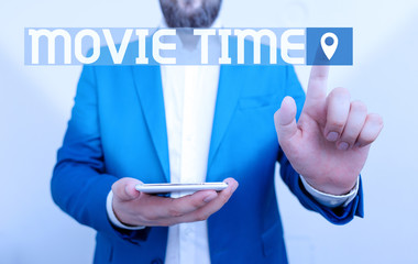 Handwriting text writing Movie Time. Conceptual photo the scheduled or actual time at which a show or film begins Businessman in the blue suite with lap top pointing with finger