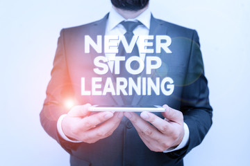 Text sign showing Never Stop Learning. Business photo text Continue to Improve and Empower your Boundaries Male human wear formal work suit hold smart hi tech smartphone use hands