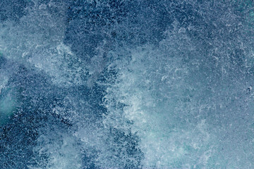 Aquatic background of sea surf waves splashing close up with clear blue green water and white foam