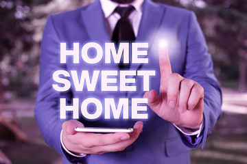 Conceptual hand writing showing Home Sweet Home. Concept meaning In house finally Comfortable feeling Relaxed Family time Businessman with pointing finger in front of him