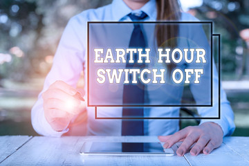 Text sign showing Earth Hour Switch Off. Business photo showcasing The Lights Out Event Annual Movement Planet Day Female business person sitting by table and holding mobile phone