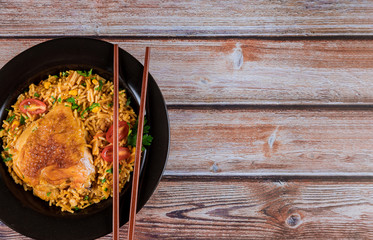 Homemade Chinese fried rice with chicken on a plate with chopsticks into the dish