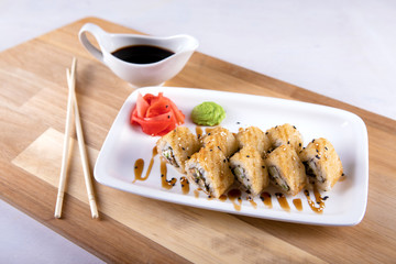 Japanese food rolls in white plate with soy sauce