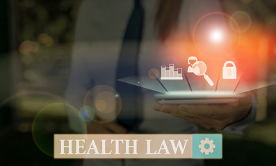 Writing note showing Health Law. Business concept for law to provide legal guidelines for the...