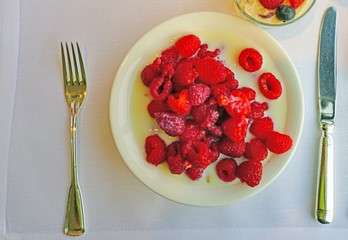 Bowl of fresh red raspberries in milk