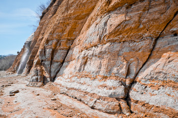 Red and white sediments along a cliff.