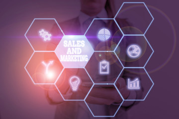 Writing note showing Sales And Marketing. Business concept for Promotion Selling Distribution of Goods or Services