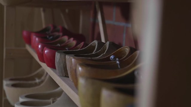 Rack with several pairs of wooden shoes.
