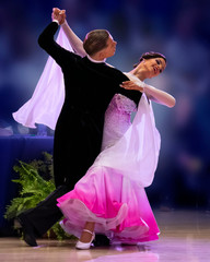A elegant ballroom couple strikes a pose on the dance floor