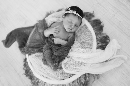 newborn baby wrapped in a blanket sleeping in a basket. concept of childhood, healthcare, IVF. Black and white photo