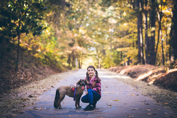 Little girl with her dog outdoors on a autumn day