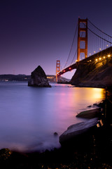 Golden Gate Bridge at night with reflection into San Francisco Bay