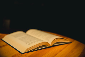 Young womman 's hand opening and reading a book, close up.  Closeup image of a woman holding and reading a book.
