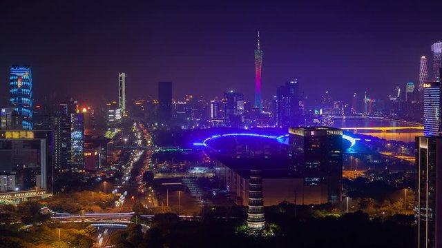 Timelapse Guangzhou China Import and Export Canton Fair surrounded by illuminated highrise buildings and overpass roads and highways at dark night