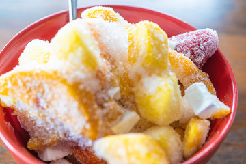 Frozen pieces of fruit in a red bowl to prepare smoothies