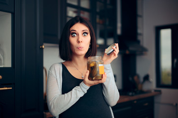 Pregnant Woman Holding a Jar of Pickles in the Kitchen