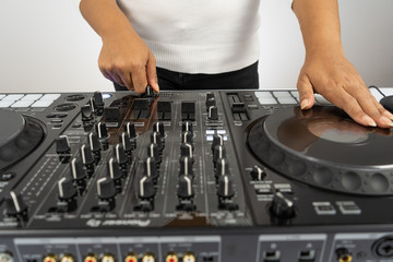 Hands of DJ mixing tracks on professional Dj Mixer