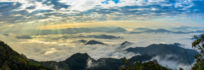 Misty mountains panorama in the morning with crepuscular sun rays during sunrise time, Phu Chi Dao Chiangrai Thailand