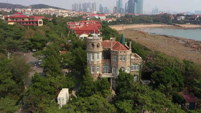 Rotating aerial view of European style historic Huashi building in the Badaguan scenic area in Qingdao, a popular coastal city for holidaymakers in China