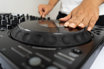 Hands of DJ mixing tracks on professional Dj Mixer