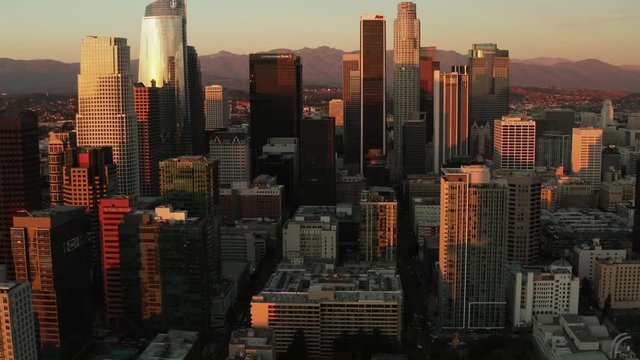 Aerial of downtown Los Angeles in dawn, sunset in California, skyscrapers and office buildings, golden light