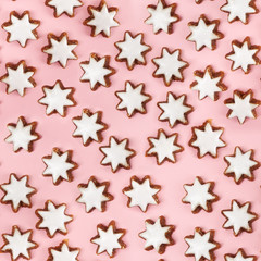 Almond stars biscuits with sugar icing on pink background - seamless pattern