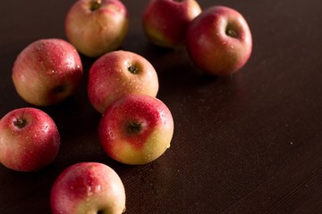 red apples on a dark wooden kitchen table